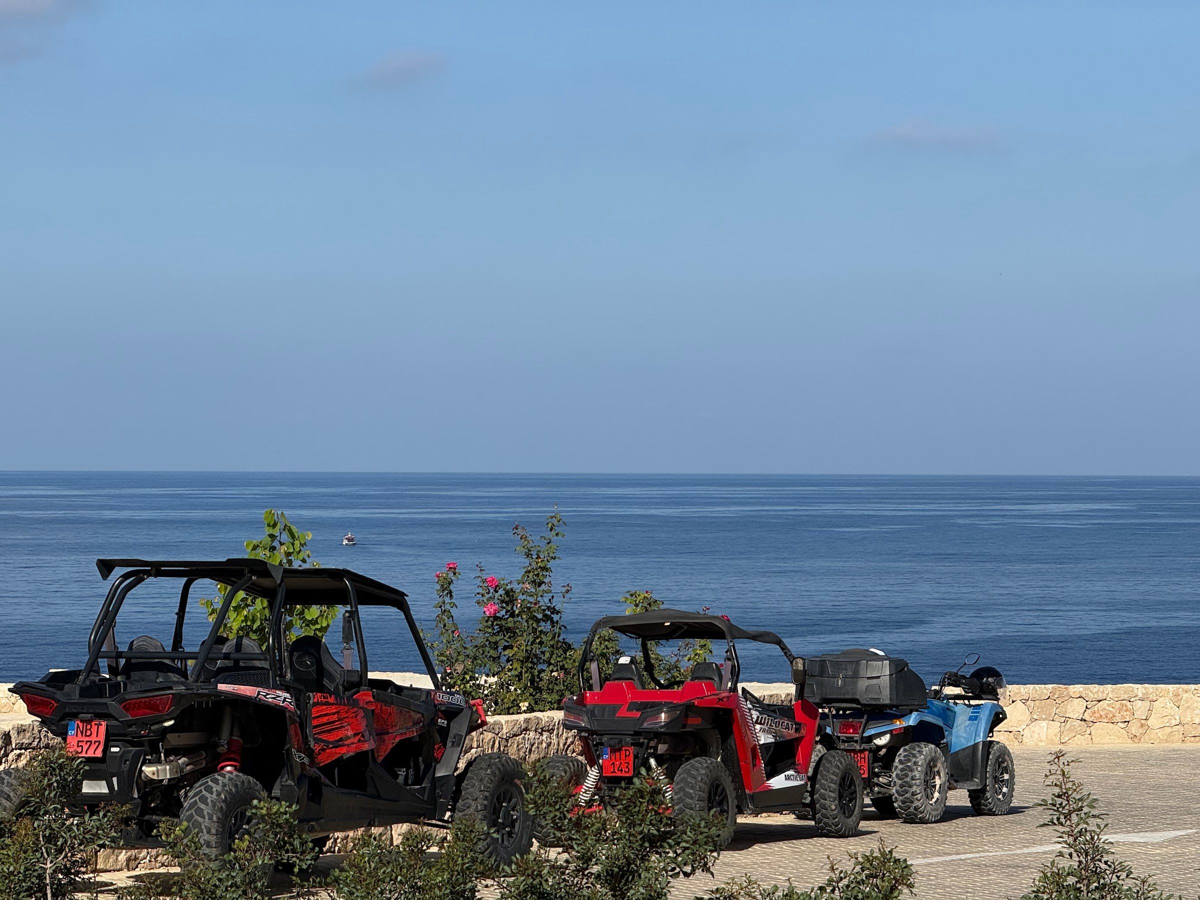 Thunder Motorsport quads and buggies parked at a Mediterranean coastal overlook