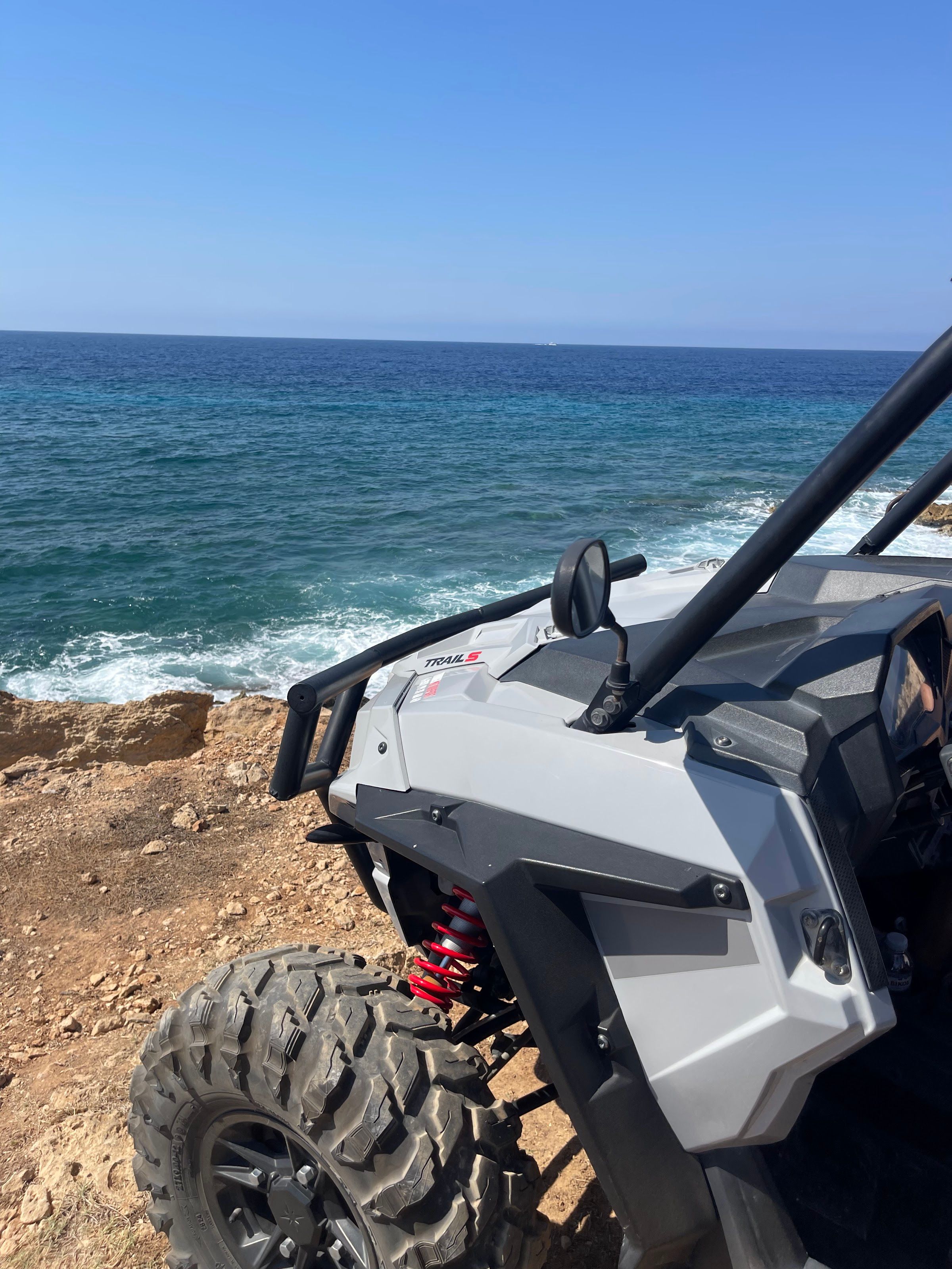 Polaris RZR Trail S buggy parked at a dramatic Cyprus coastal cliff edge